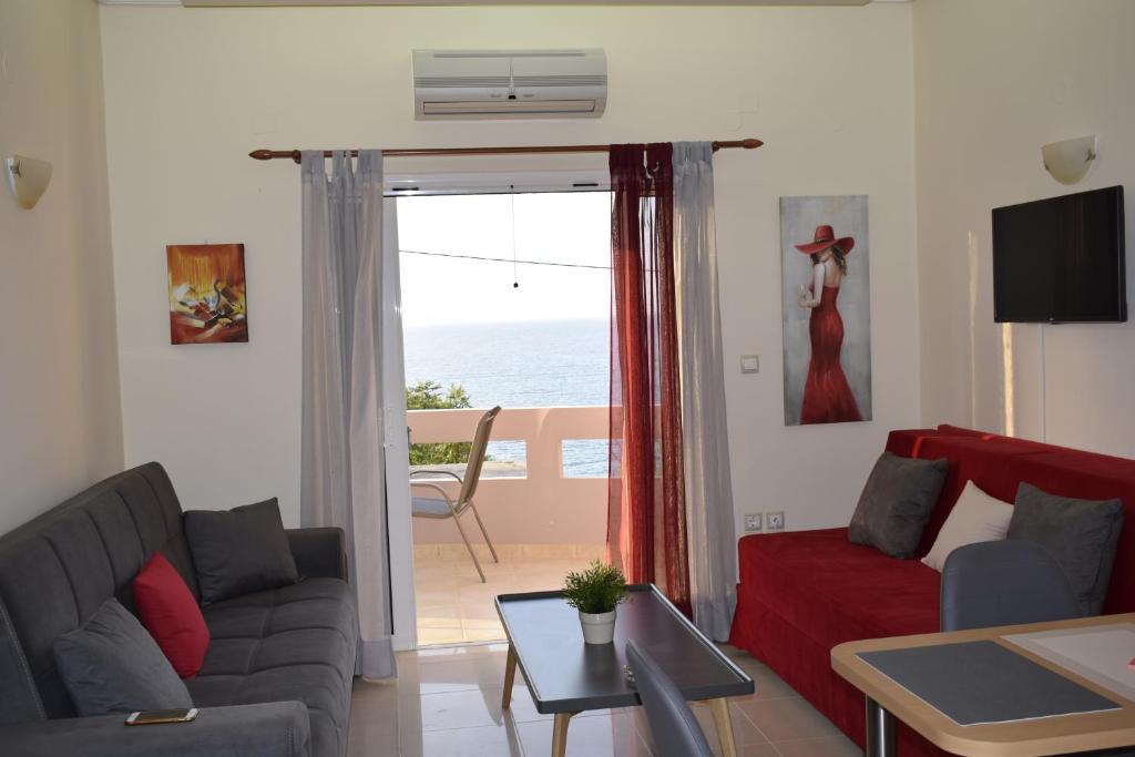 a living room with a couch and a view of the ocean at Astrantia in Chania
