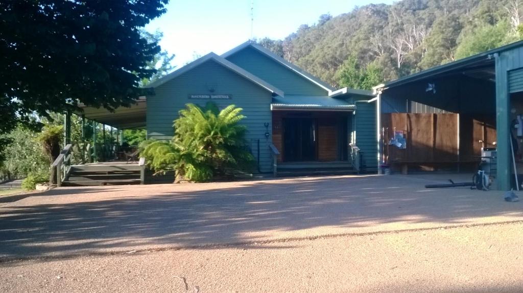 a green building with a tree in front of it at Riverbend Homestead in Bright