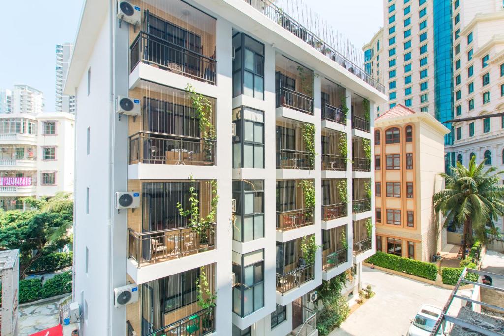 un edificio de apartamentos con plantas en los balcones en Sanya Passion fruit Inn, en Sanya