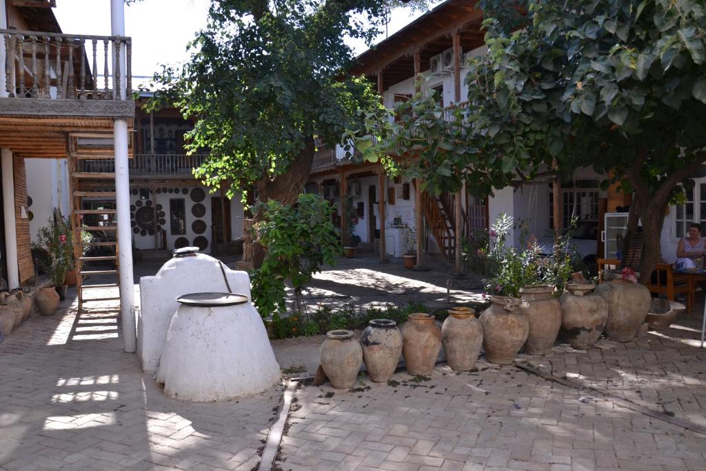 فندق ليجند في سمرقند: صف من المزهريات جالسة على الرصيف أمام المبنى