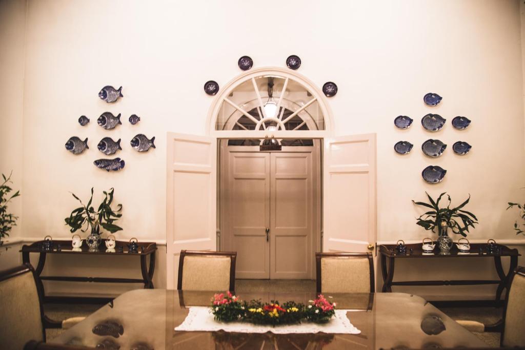 a room with two tables and a door with plates on the wall at Wild Mahseer in Tezpur