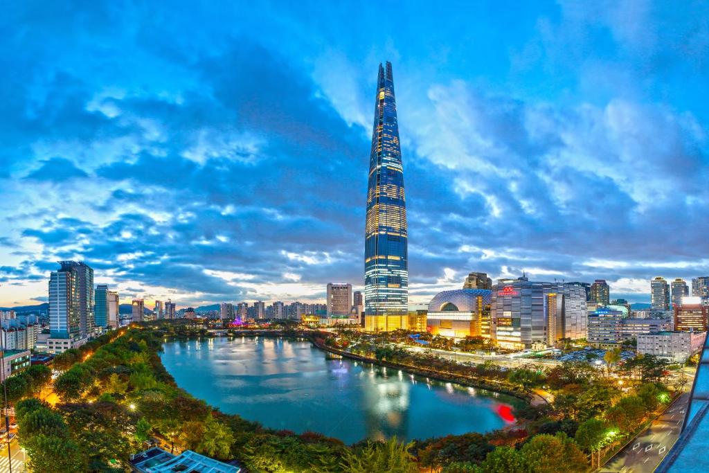 a city skyline with a river and a tall skyscraper at Signiel Seoul in Seoul