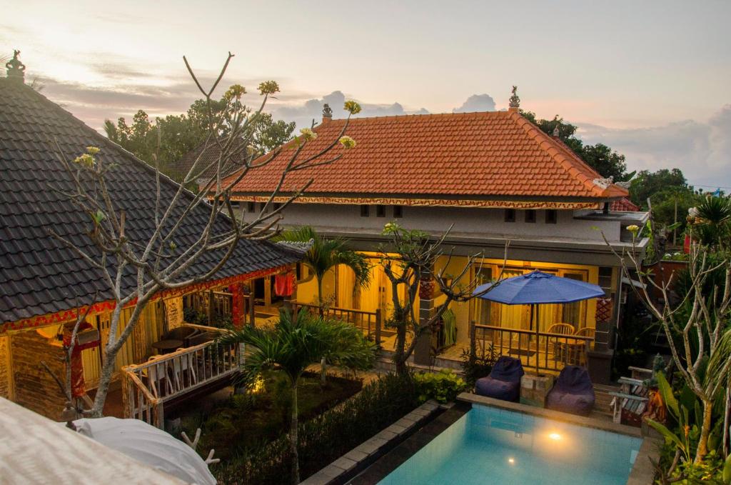 a house with a swimming pool in front of it at Kakiang Guesthouse in Nusa Lembongan