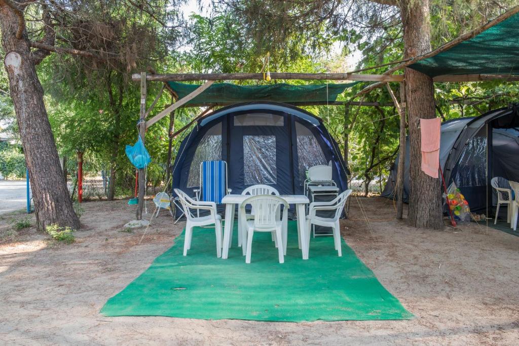 a tent with a table and chairs on a green rug at Camping Pitsoni in Sykia Chalkidikis