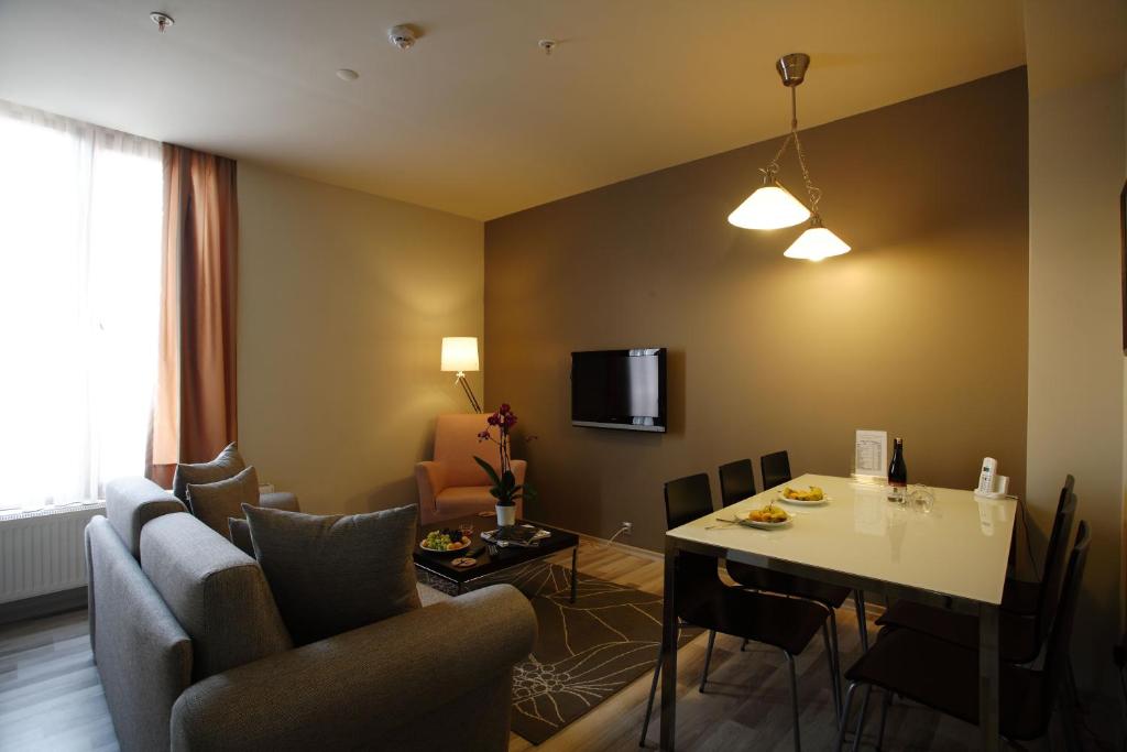 ein Wohnzimmer mit einem Tisch und Stühlen sowie ein Zimmer in der Unterkunft Home Stay Home Sisli in Istanbul