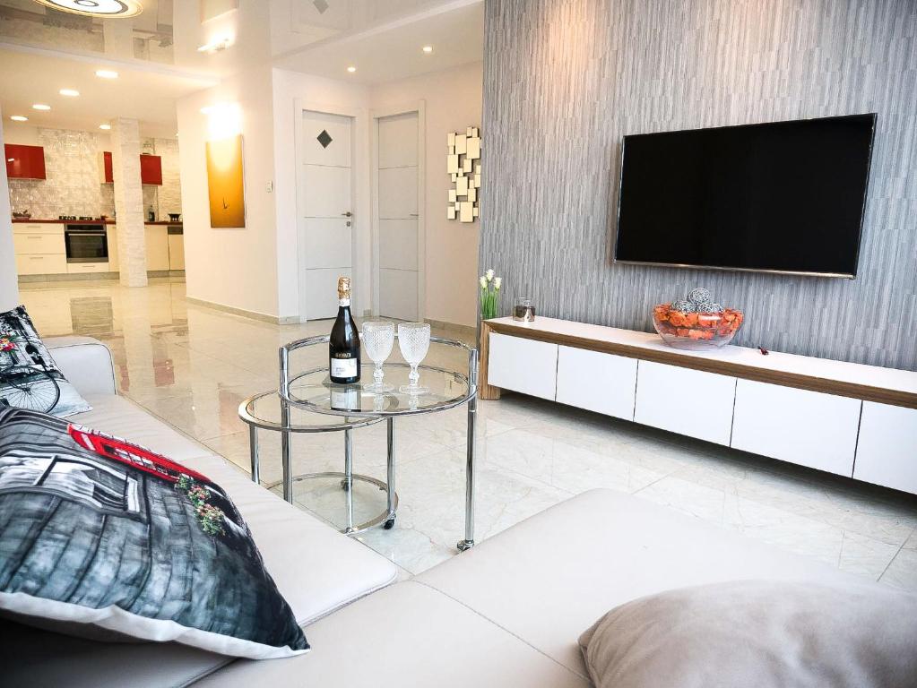 a living room with a tv on a wall at FaRoyal Luxury Suite in Eilat
