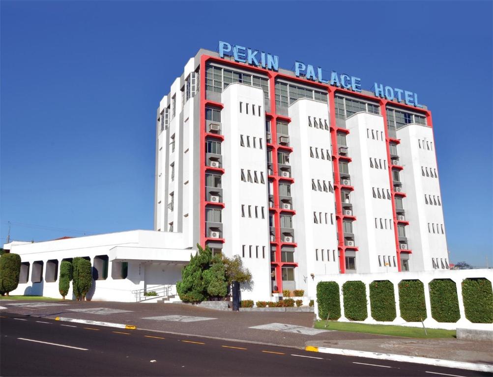 a large white building with a sign on it at Pekin Palace Hotel in Araçatuba