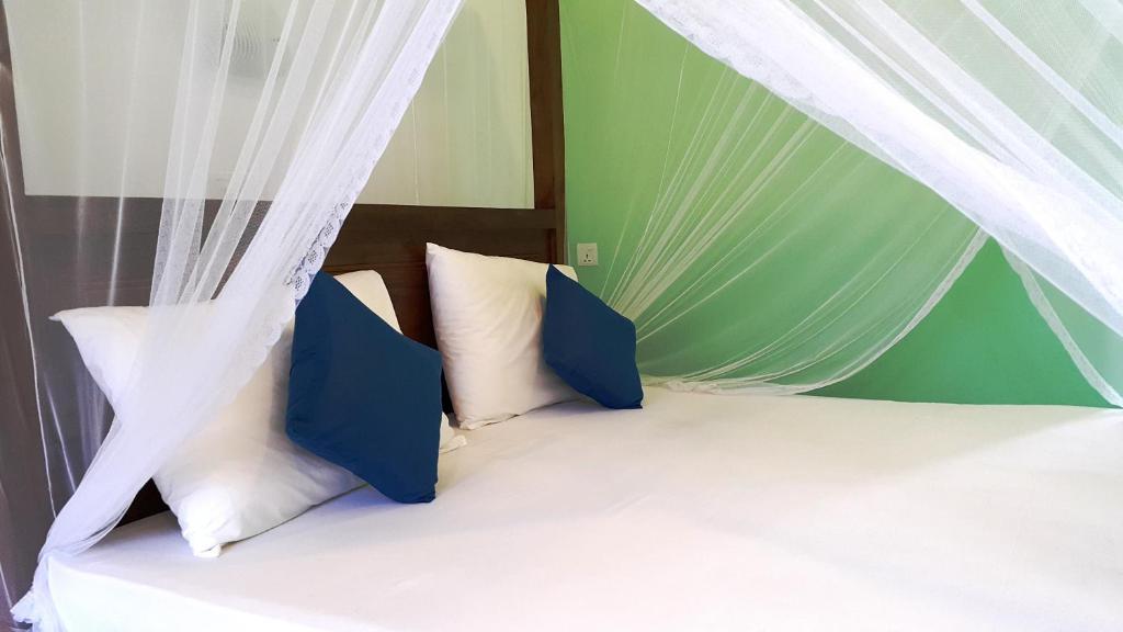 uma cama com almofadas azuis e brancas numa tenda em Moonlit Bay Weligama em Weligama