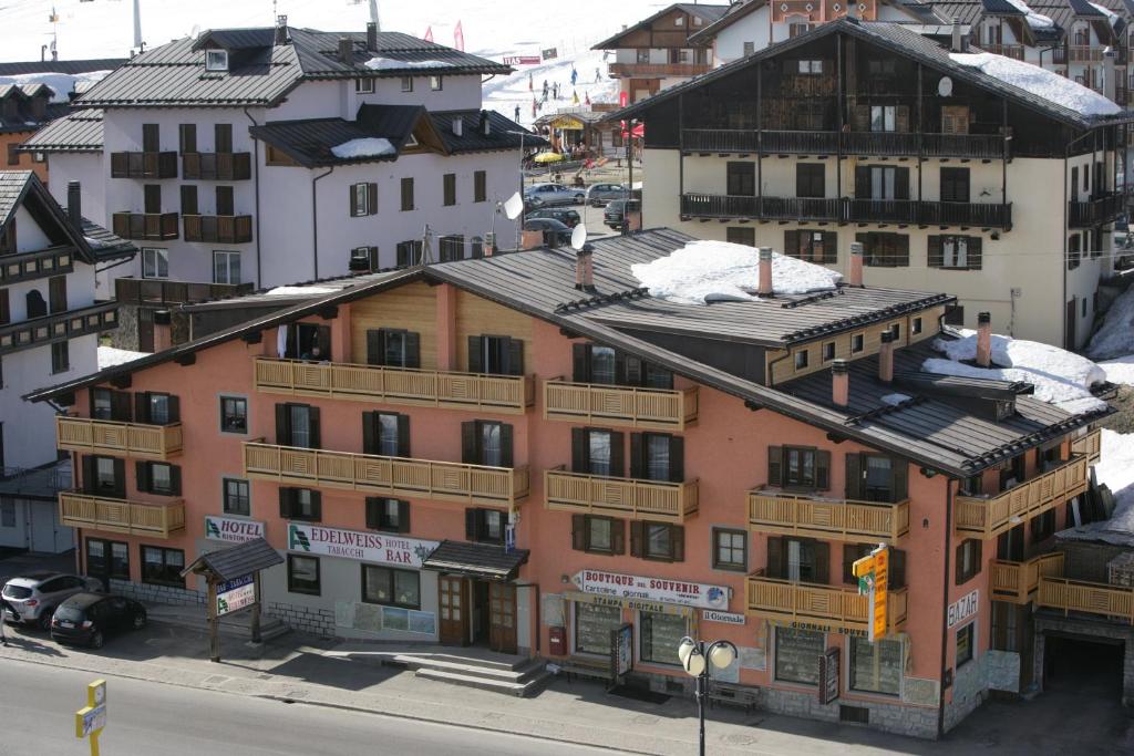 a group of buildings with snow on the roofs at Hotel Edelweiss in Passo del Tonale