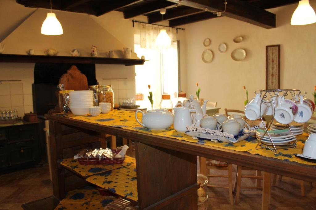 un tavolo con un mucchio di tazze e piatti sopra di B&B Antica Biblioteca a Fermo
