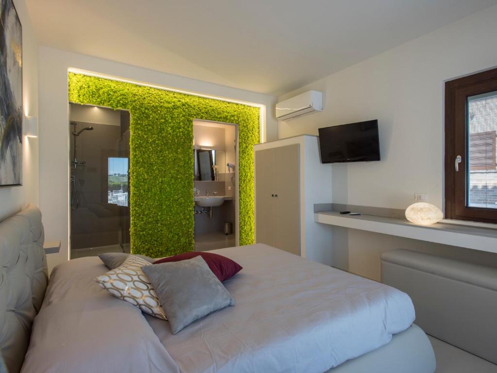 1 dormitorio con una pared verde y 1 cama en Osteria dei Segreti, en Appignano