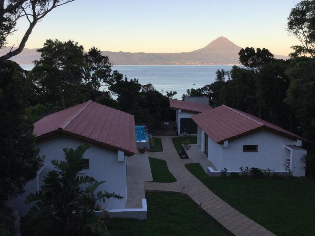 a view of two houses with a mountain in the background at Villas Casteletes in Urzelina