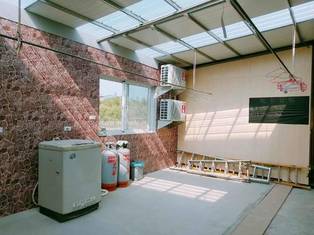 a large room with a brick wall and a window at Song Youf Hostel in Zhongpu