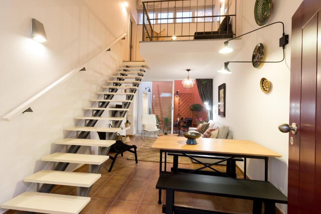 a spiral staircase in a home with a table and a dining room at Casa do Sul in Évora