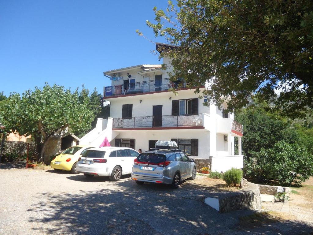 eine Gruppe von Autos, die vor einem Gebäude geparkt sind in der Unterkunft Apartments Vrša in Seline