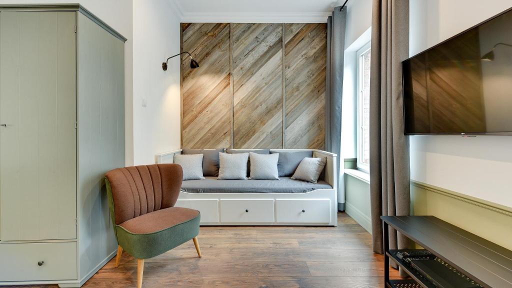 a living room with a couch and a chair at Dom & House - Apartments Old Town Ogarna in Gdańsk