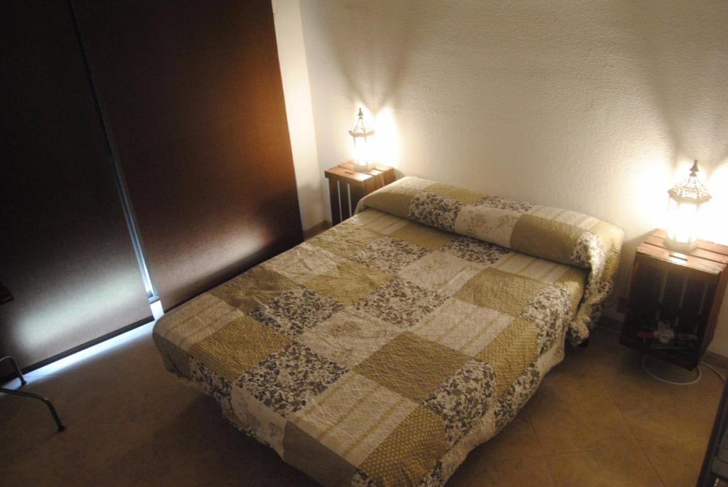 a bedroom with a bed and two lights on two tables at Apartamento Avenida Parque in Córdoba