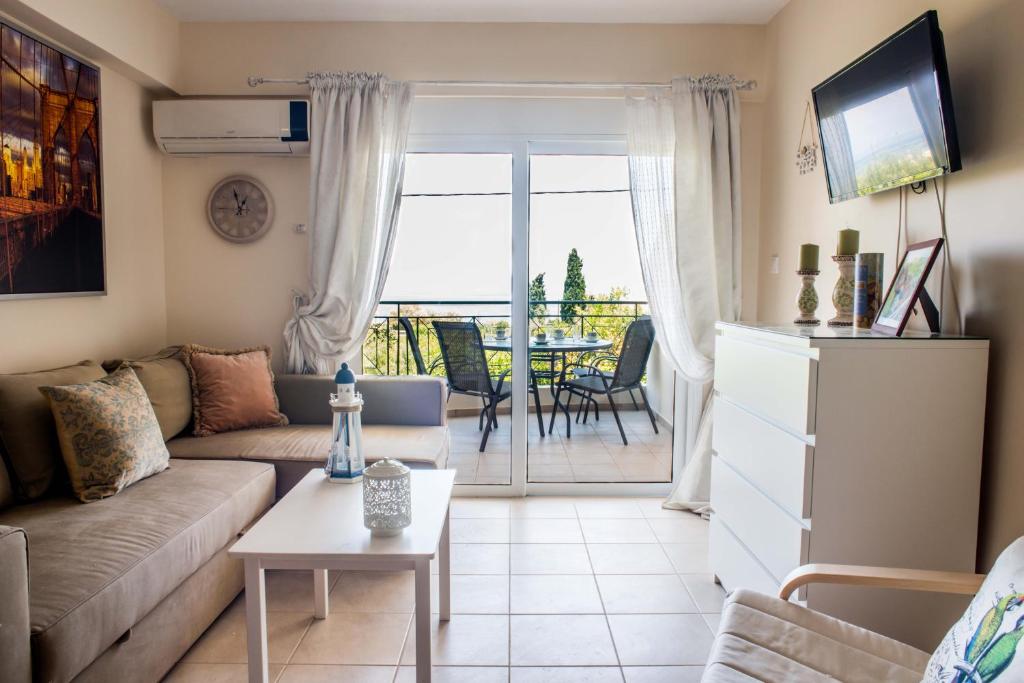 - un salon avec un canapé et une table dans l'établissement Lovely Apartment Next to the Sea Lygia Korinthias, à Liyiá