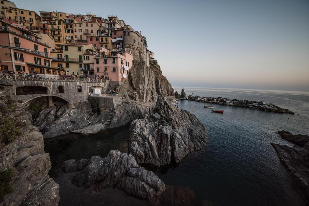 a group of houses on a cliff next to the water at 5 Terre Lodge in La Spezia