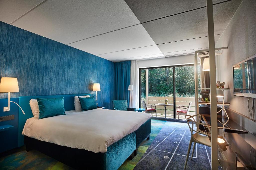 een slaapkamer met een bed en een blauwe muur bij Carlton President in Utrecht