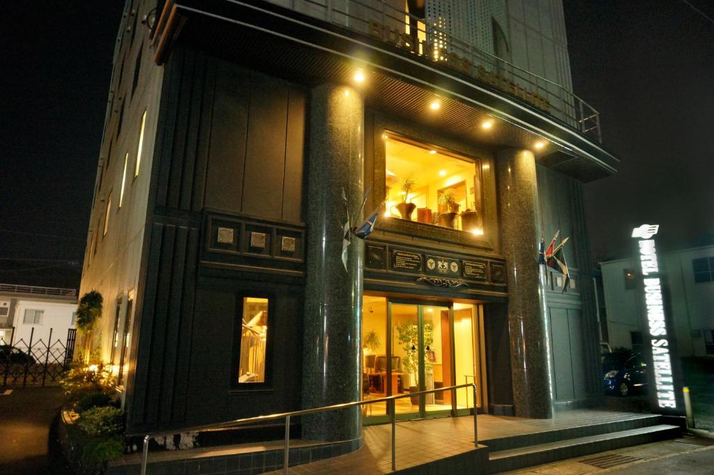 Hotel Satellite في Satsumasendai: مبنى مع شرفه في الليل