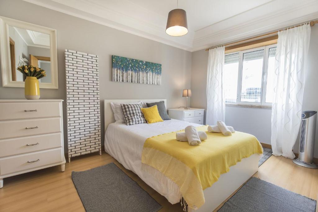 a bedroom with a bed with a yellow blanket at LovelyStay - Charming Marques Flat in Lisbon