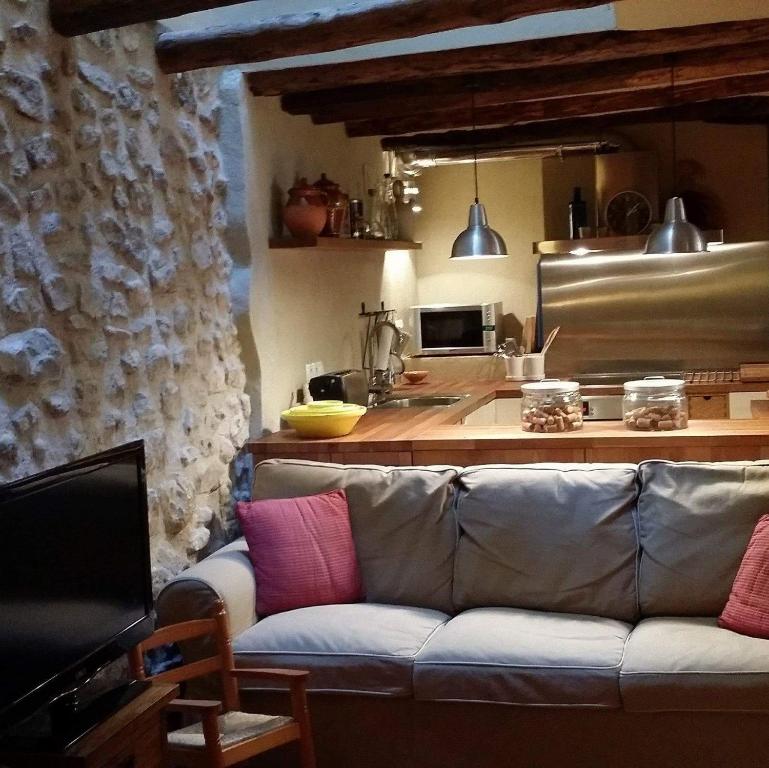 salon z kanapą i kuchnią w obiekcie Ca La Serrana w mieście Bot