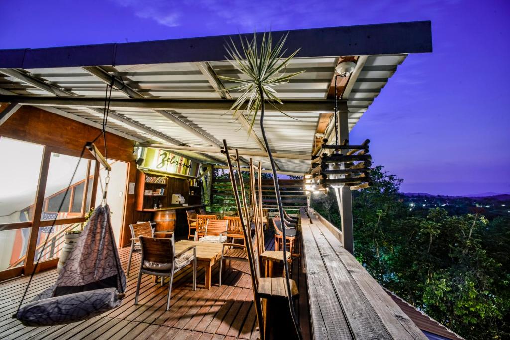 a patio with chairs and tables on a deck at Zebrina Guest House in Nelspruit