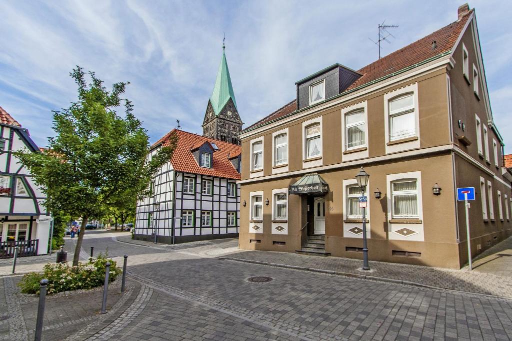 a street with two buildings and a church at Hotel Alt Westerholt in Herten
