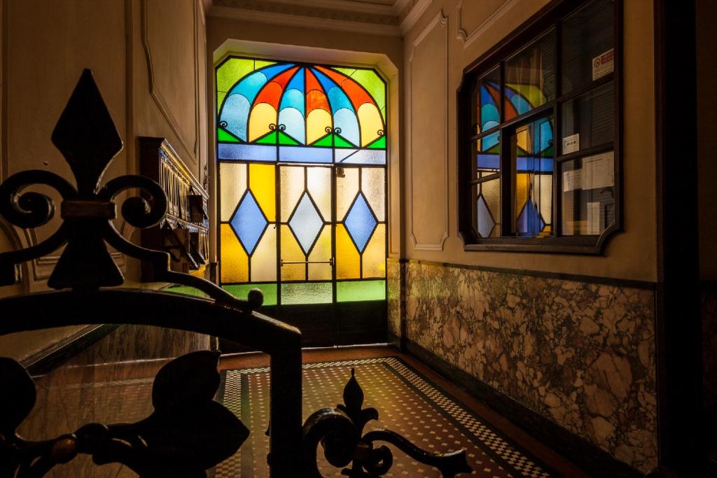 a room with a stained glass window and a staircase at Bronzino House in Milan