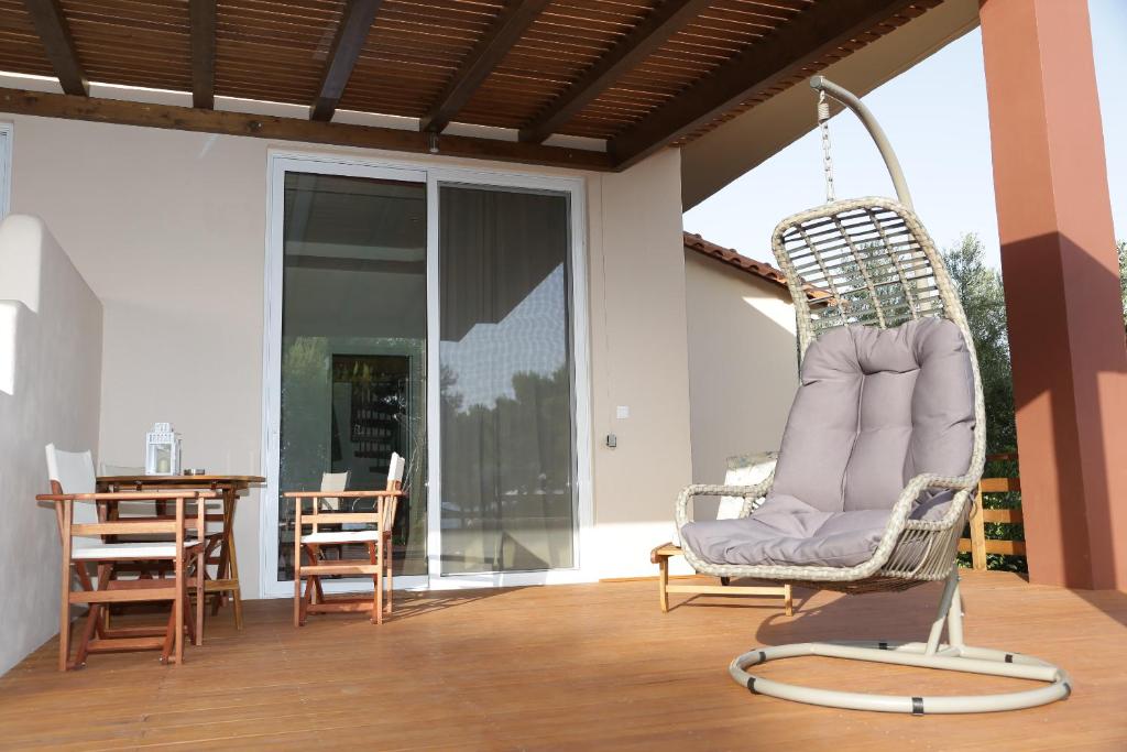 a porch with a swinging chair and a table at Artemis Suites in Romanós