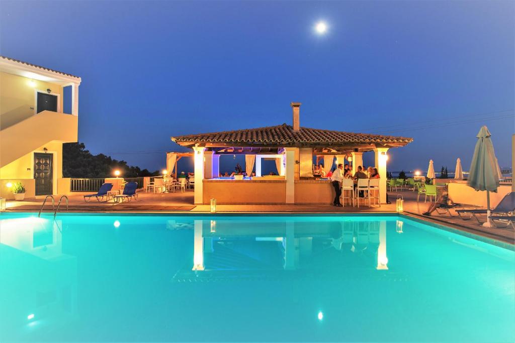 a swimming pool in front of a house at Corfu Aquamarine Hotel in Nisaki