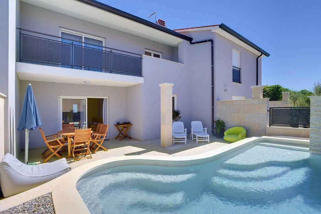 ein Swimmingpool vor einem Haus in der Unterkunft Holiday Home Baldini in Banjole