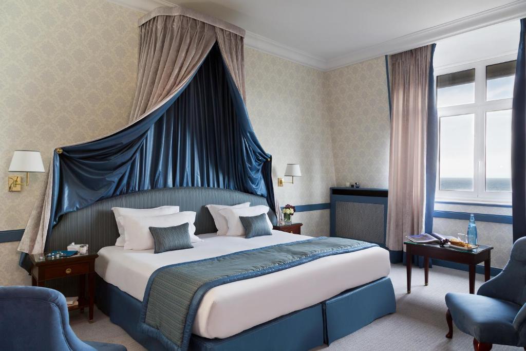 Кровать или кровати в номере Hôtel Barrière Le Royal Deauville