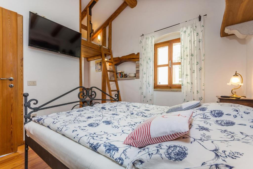 a bedroom with a bed with a blue and white comforter at Guesthouse Casa Nova in Poreč