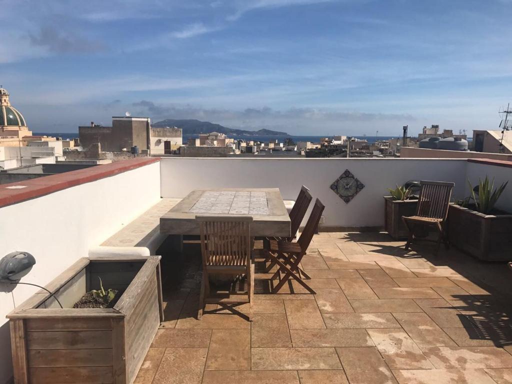 a patio with a table and chairs on a roof at Favignana Margot House in Favignana