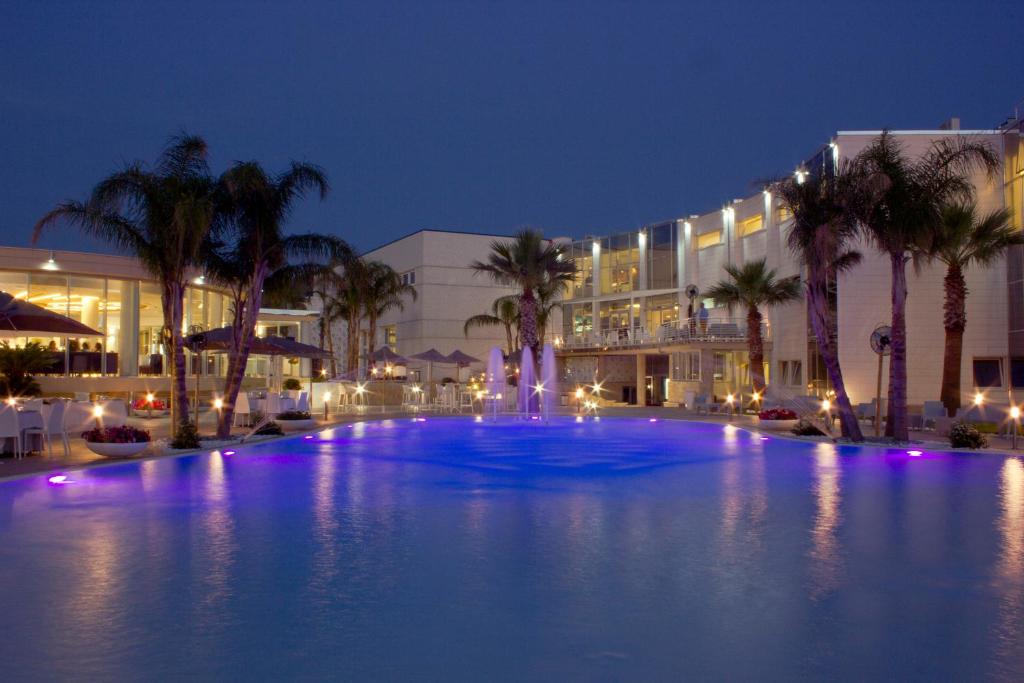 una gran piscina con palmeras y un edificio en DubaiVillage, en Camposano