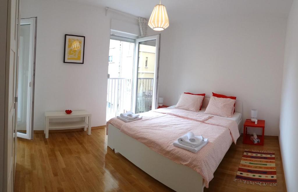 um quarto branco com uma cama com duas toalhas em Apartment Homey em Zadar