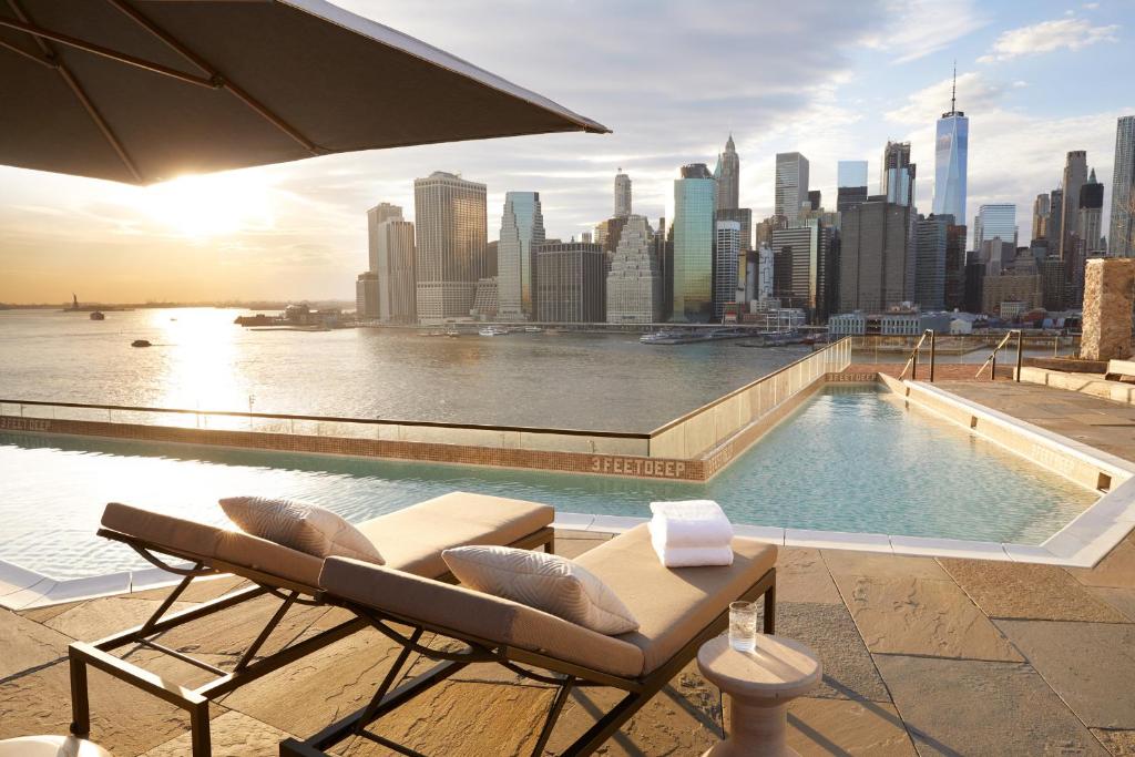 a pool on top of a building with a view of a city at 1 Hotel Brooklyn Bridge in Brooklyn