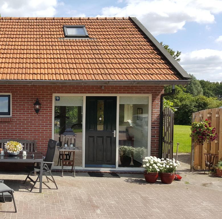 a small red brick house with a sliding glass door at Vakantiehuis "Aan de Zandweg" in Roderesch