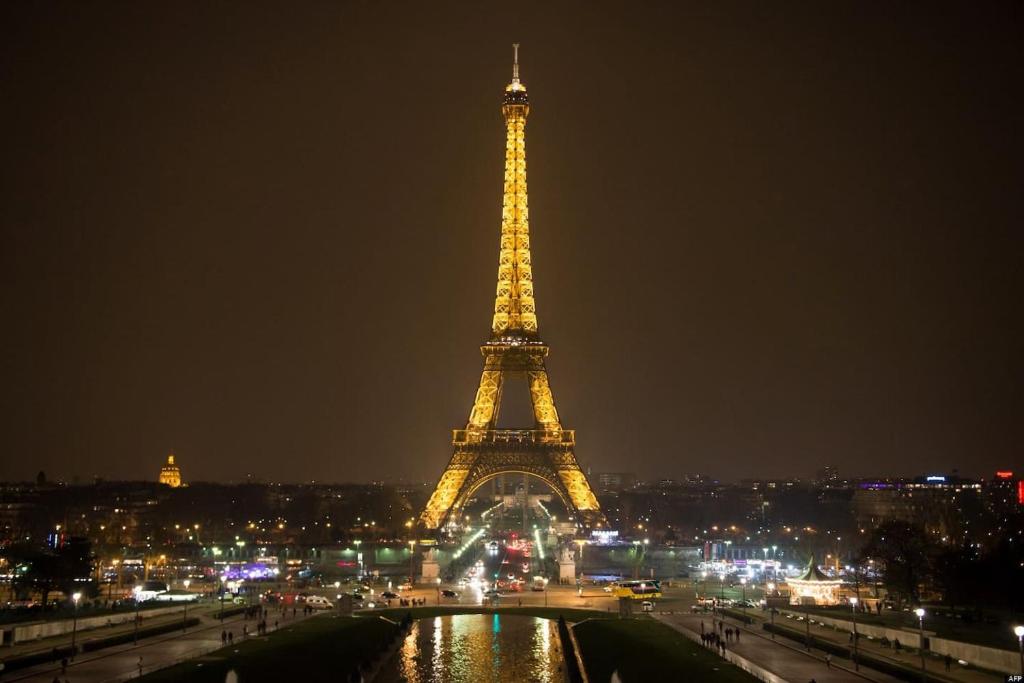 uma vista para a torre Eiffel à noite em Longchamp Apartment em Paris