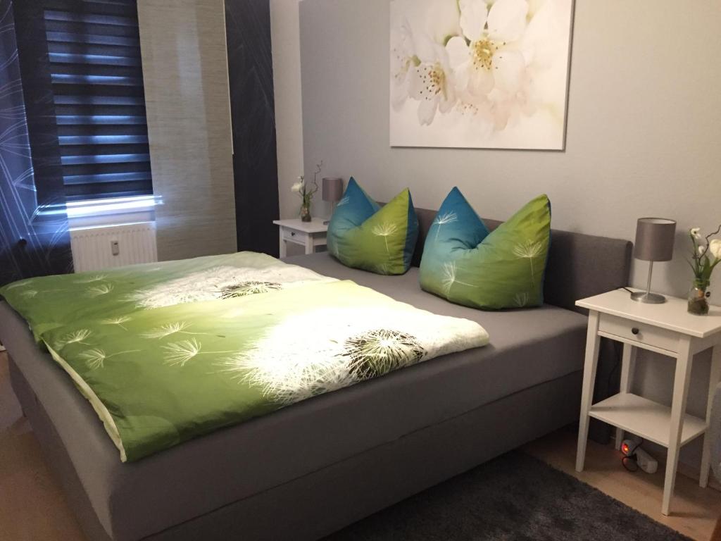 1 cama con almohadas verdes y azules en una habitación en Am alten Stadtgefängnis, en Naumburg