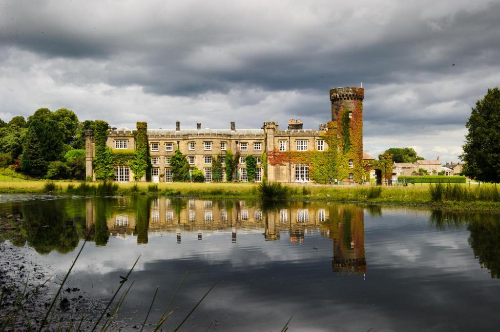 a castle with its reflection in the water at Swinton Park in Masham