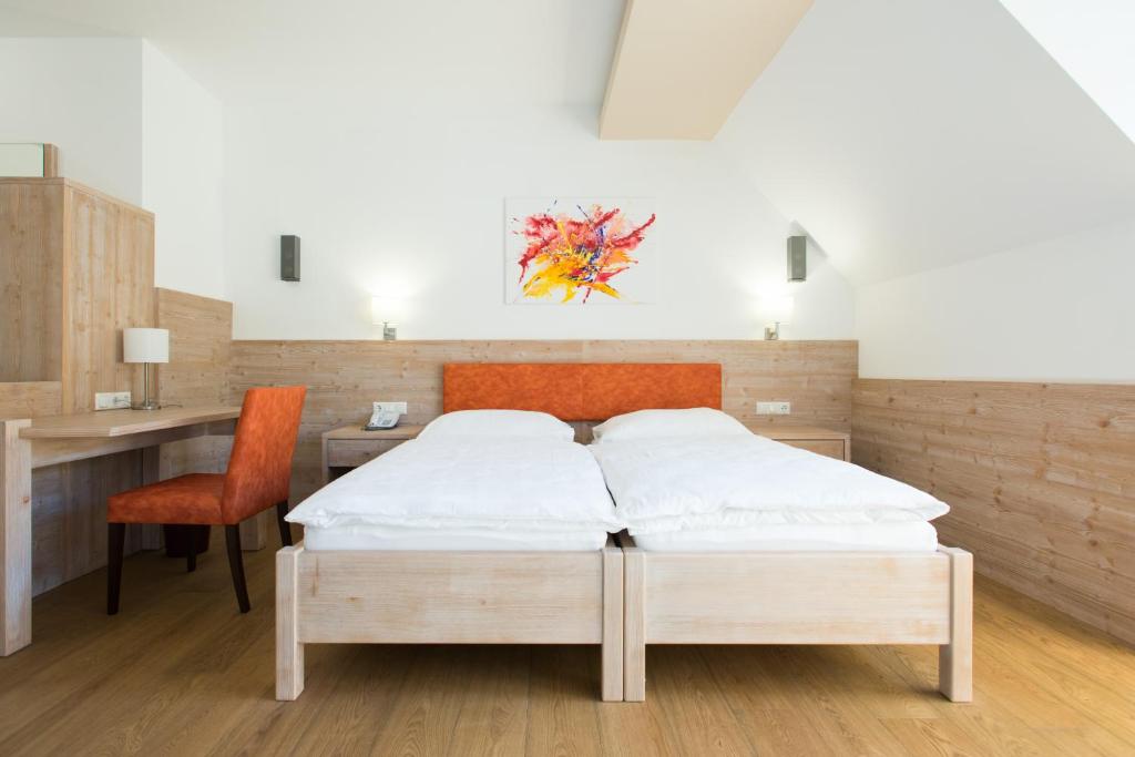 Schlafzimmer mit einem Bett, einem Schreibtisch und einem Stuhl in der Unterkunft Hotel Vösenhuber in Ernsthofen