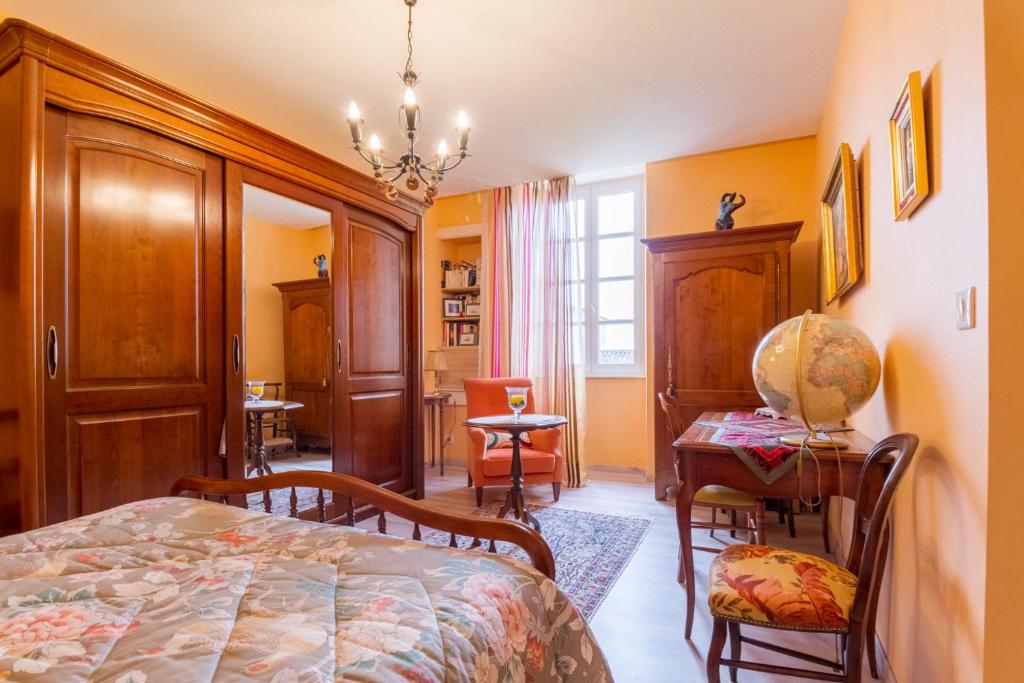 a bedroom with a bed and a table and chairs at Chambres d'Hôtes Saint Roch in Tournecoupe