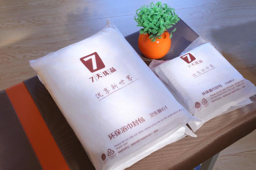 a couple of bags sitting on a table with a plant at 7Days Premium Beijing Gulou in Beijing