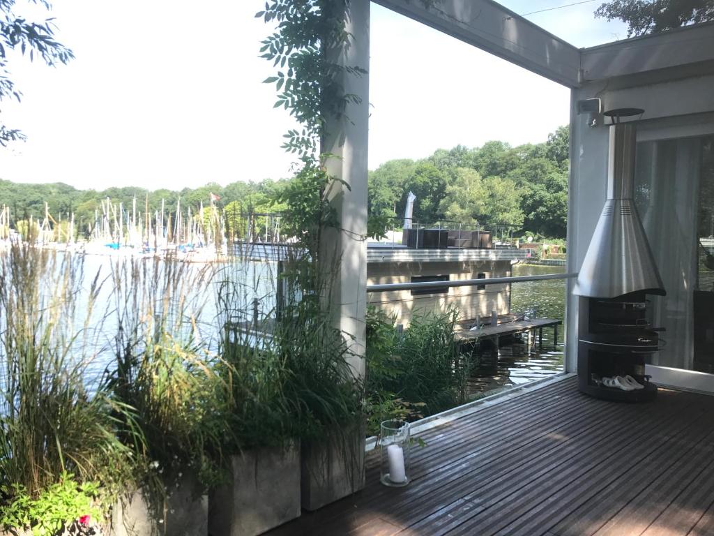 a screened porch with a grill and a view of a lake at Haus direkt am See in Berlin