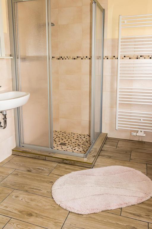 a bathroom with a shower with a rug and a sink at Gästehaus Margareth in Büsum
