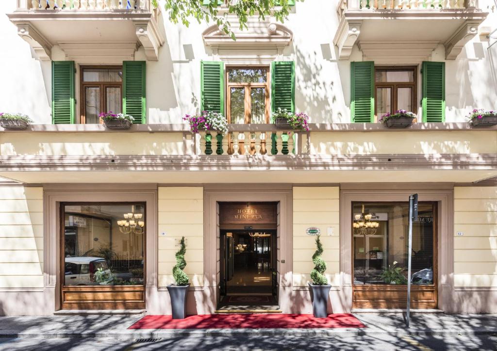 a facade of a building with green shutters at Hotel Minerva Palace in Montecatini Terme