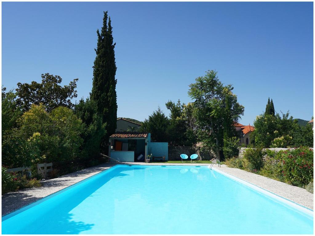 une grande piscine bleue dans une cour dans l'établissement Chambre d'Hôte La Romaine, à Vaison-la-Romaine
